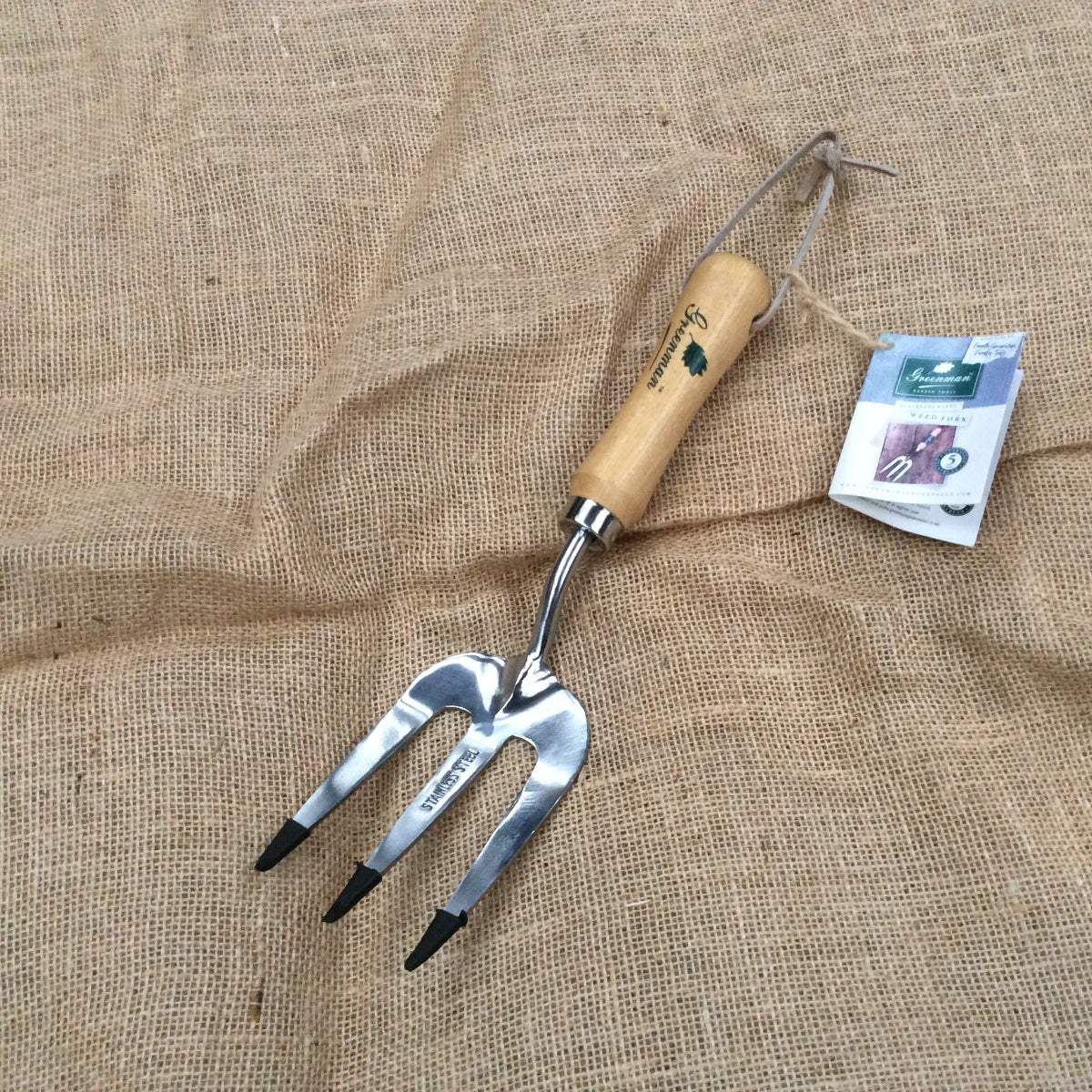 Weed fork with stainless steel forks on a hessian background